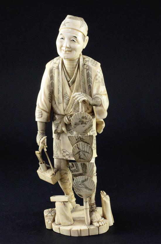 A Japanese sectional walrus ivory figure of a fan seller, early 20th century, 27.5cm